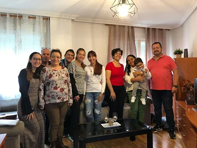Hermanos y hermanas de la congregación reunidos en el salón de casa